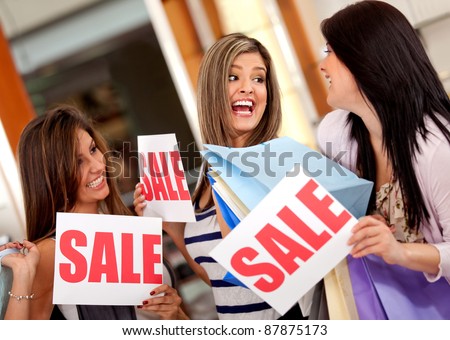 Excited group of women with bags shopping on sale