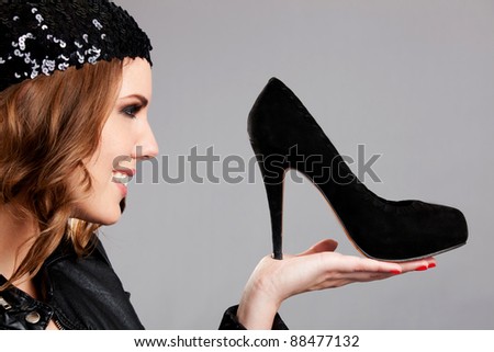 Fashion woman looking at high-heel shoes and smiling