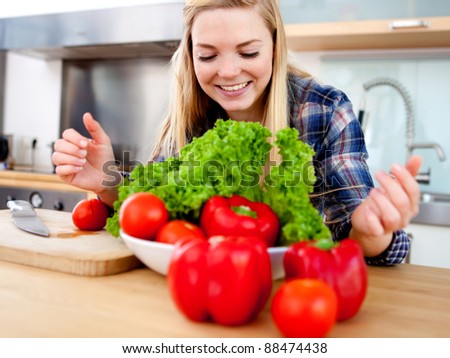 Young female cook making a fresh salad with organic vegetables