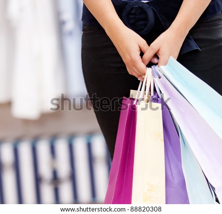 female person holding a shopping bags in a store