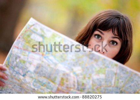 Lost woman in the countryside holding a map