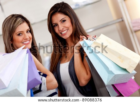 Happy female shoppers at a shopping center with bags