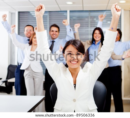 Business woman leading a successful group with arms up
