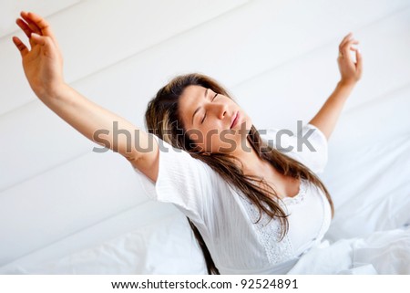 Lazy woman in bed waking up and yawning