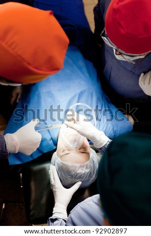 Group of doctors operating on a female patient