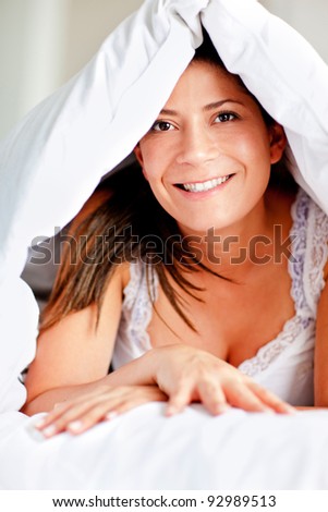 Happy woman in bed under the blankets