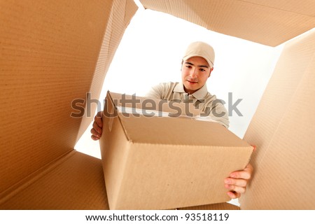 Delivery man holding a package inside a cardboard box