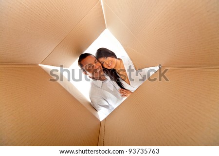 Couple in a cardboard box ready to move house