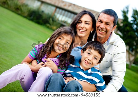 Happy family outdoors with a house at the background