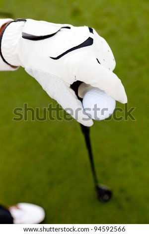 Close-up of a hand wearing a glove and holding a golf club