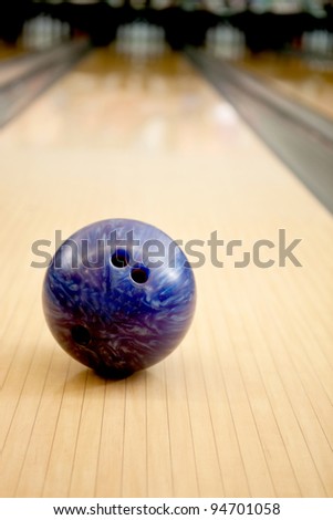 Close-up of a purple bowling ball in an alley