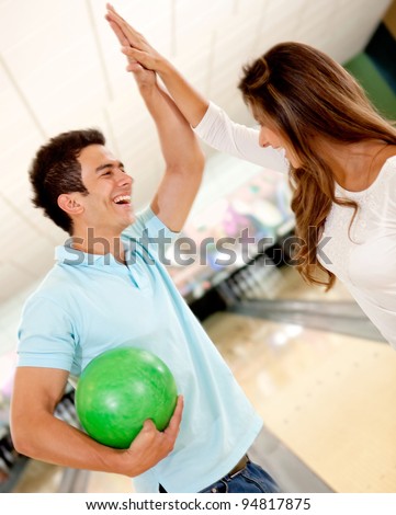 Happy team winning at bowling and giving a high-five