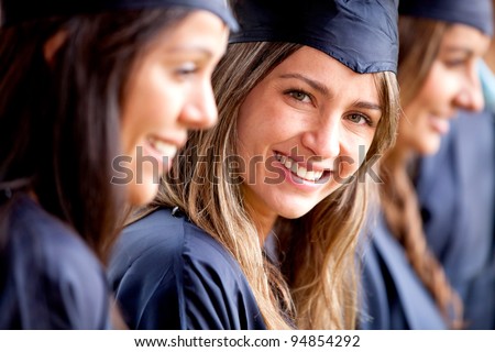 Beautiful female graduate standing out from a group of students