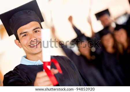 Happy male graduate holding his diploma and smiling