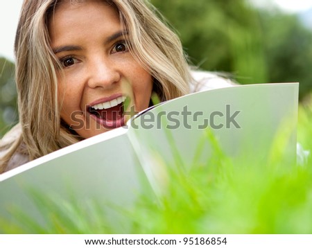 Beautiful woman reading outdoors and looking surprised