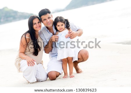 Family smiling at the beach enjoying their vacations