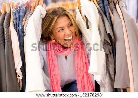 Excited woman shopping clothes on sale at retail store