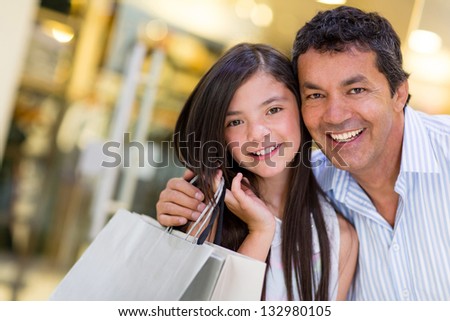 Portrait of beautiful girl and father smiling at the mall