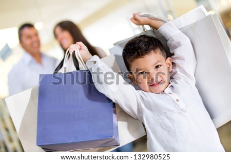 Happy Little Boy Holding Shopping Bags With His Family