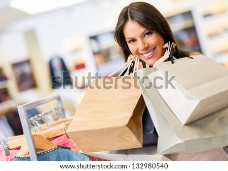 Portrait of beautiful shopaholic holding her shopping bags inside a store.