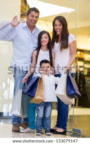 Happy family shopping and holding bags at the mall
