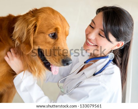 Vet examining a cute dog and smiling