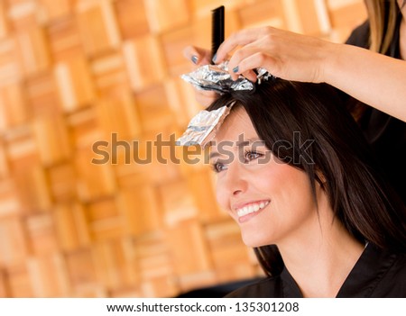 Woman coloring her hair at the beauty salon