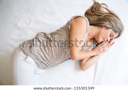 Tired woman sleeping on a bed having sweet dreams