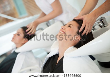 Happy woman at the salon getting a hair wash