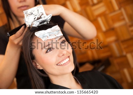 Woman dying her hair at the beauty salon