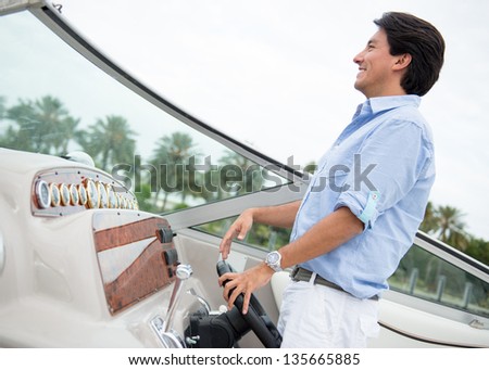 Handsome man behind the wheel of a boat smiling