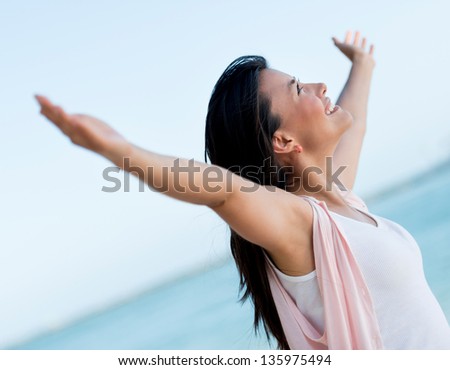 Woman with arms open looking very happy celebrating