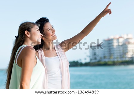 Portrait of two happy girls pointing away and smiling