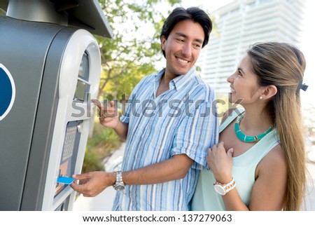 Couple paying for parking with a debit card