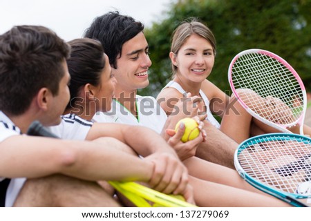 Happy group of tennis players at the court