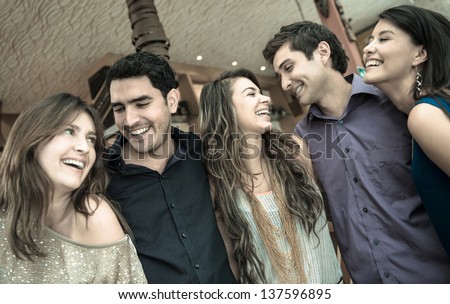 Group of people at the bar looking very happy and laughing