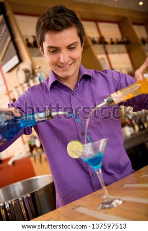 Male barman making a cocktail at the bar