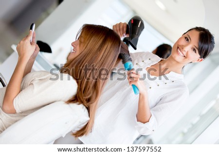 Hairdresser blowing woman\'s hair at the beauty salon