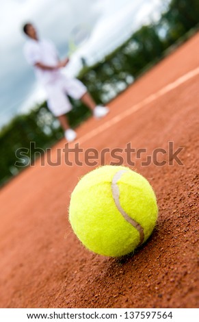 Tennis match at a clay court with a ball lying on the side