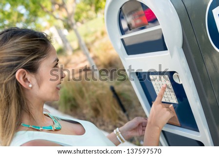 Girl paying for parking at a payment station
