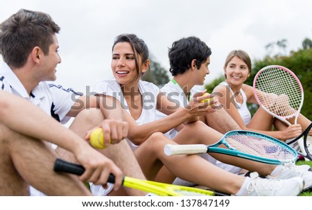 Group of happy tennis players resting outdoors