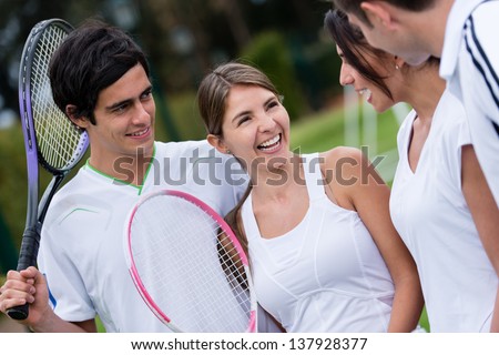 Group of friends at the club playing tennis