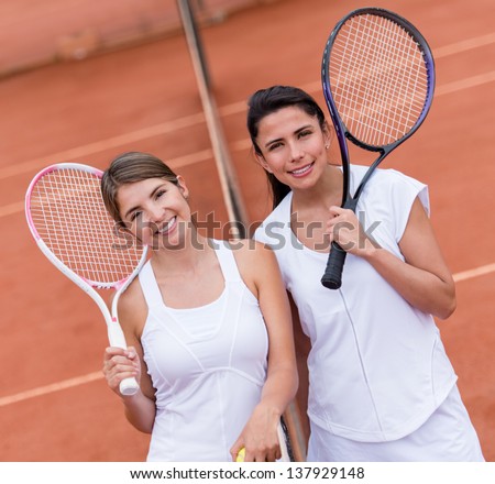 Female tennis players looking happy at a clay court