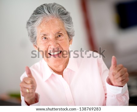 Portrait of a happy senior woman with thumbs up