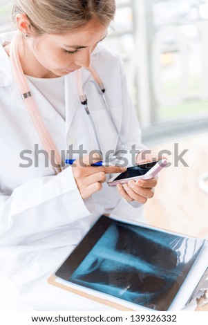 Female doctor working at the hospital and using a smart phone Female doctor working at the hospital and using a smart phone