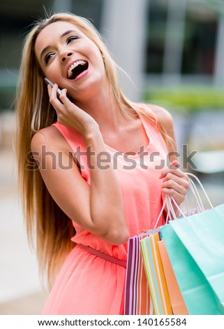 Happy female shopper talking on the phone and smiling