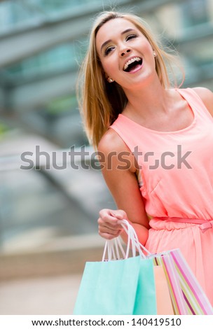 Very happy shopping woman at the mall holding bags