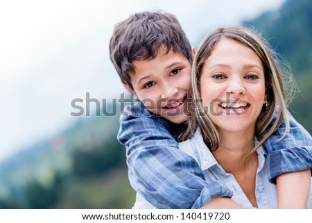 Portrait of a happy mother and son smiling outdoors