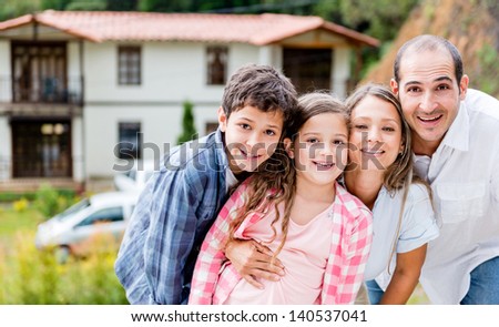 Happy Family Outside Their House In The Countryside