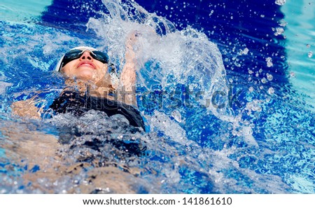 Woman Swimming At The Pool On Her Back